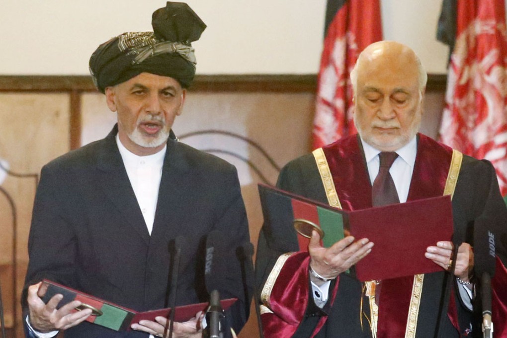 Ashraf Ghani (left) takes an oath of office as Afghanistan's new president in Kabul on September 29, 2014.