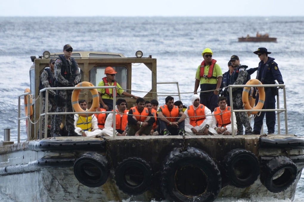 Australian customs and navy personnel escort rescued asylum-seekers. Photo: Reuters