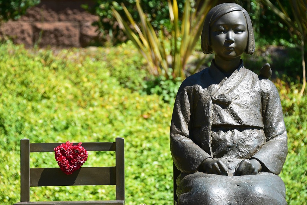 The Comfort Woman statue, with bird on shoulder, beside an empty chair symbolizing survivors who are of an old age without having yet witnessed judgement, in Glendale, California. Photo: AFP
