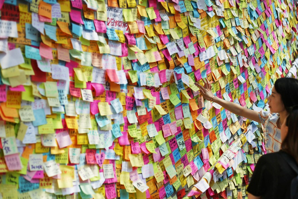 Protesters read the notes of support on a wall outside the government headquarters in Admiralty yesterday.Photo: Sam Tsang