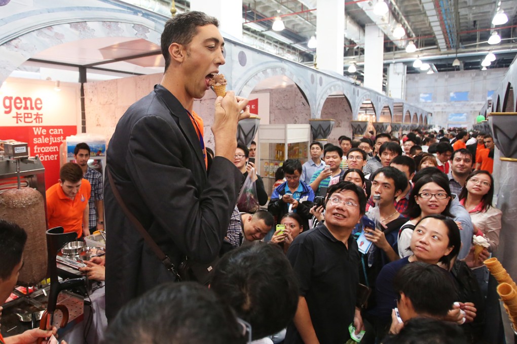 Sultan Kösen, 2.51-meter-high, the tallest man in the world living in Turkey, eats an ice cream corn at the three-day Turkish Culture & Food Festival in this October 06, 2013 file picture in Shanghai.
