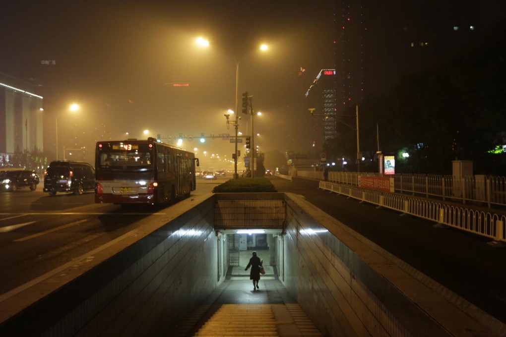 A woman walks through an underground passage on a hazy night in central Beijing as smog chokes the city. Photo: Reuters