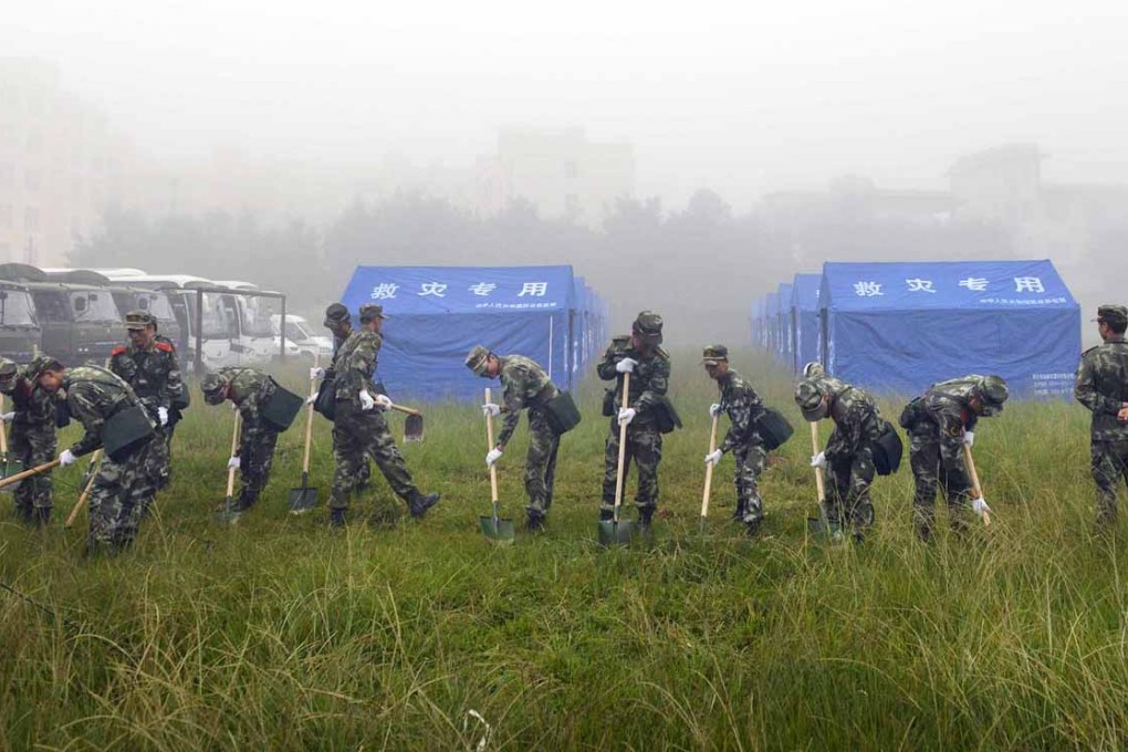 In Jinggu county, paramilitary police dig a ditch around a settlement for quake victims. Photo: EPA