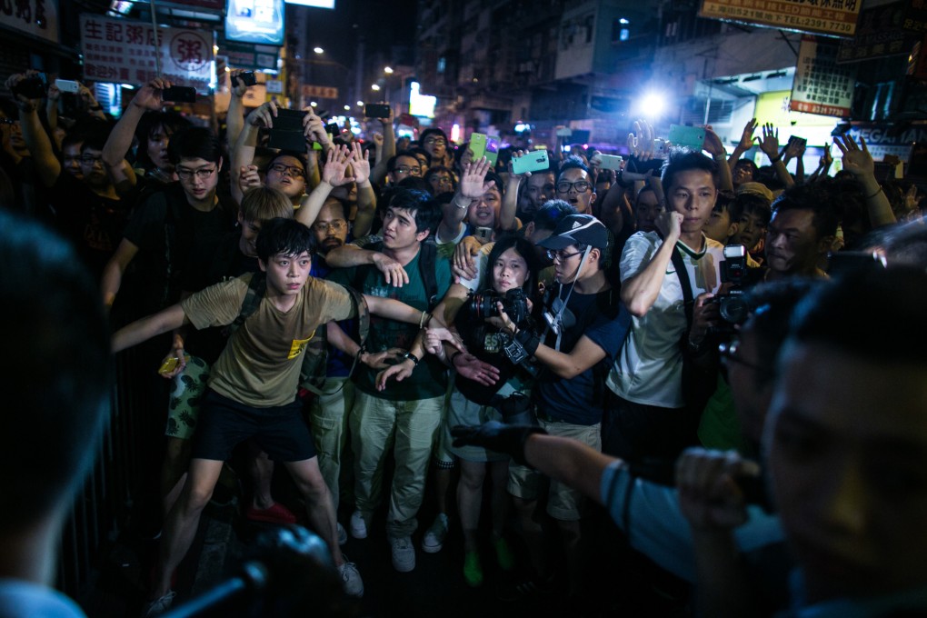 Demonstrators stand their ground in front of police officers in the occupied areas in Mong Kok. Photo: Bloomberg