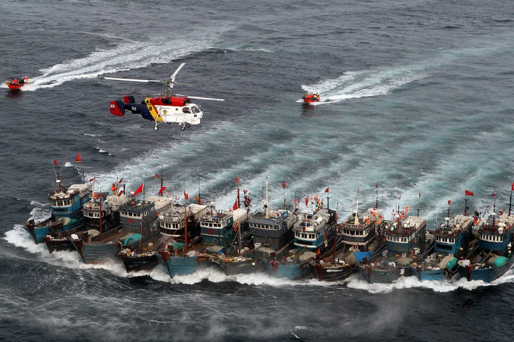 File picture from November 2011 shows Chinese fishing boats bound together with ropes chased by a South Korean coastguard helicopter and rubber boats packed with commandos, after alleged illegal fishing in the Yellow Sea. Photo: AFP