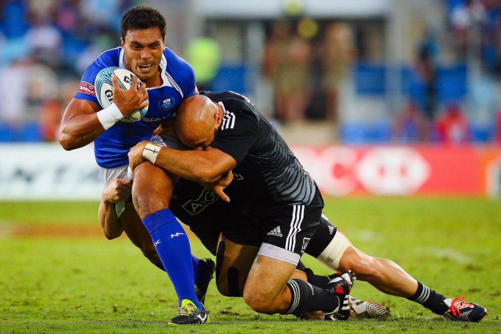 New Zealand's DJ Forbes tackles Joseph Poyer of American Samoa on day one of the Gold Coast Sevens in Australia. Photo: AFP