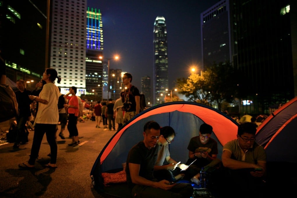 Protesters settle in for another night on the streets in Admiralty, as government leaders leave town. Photo: EPA