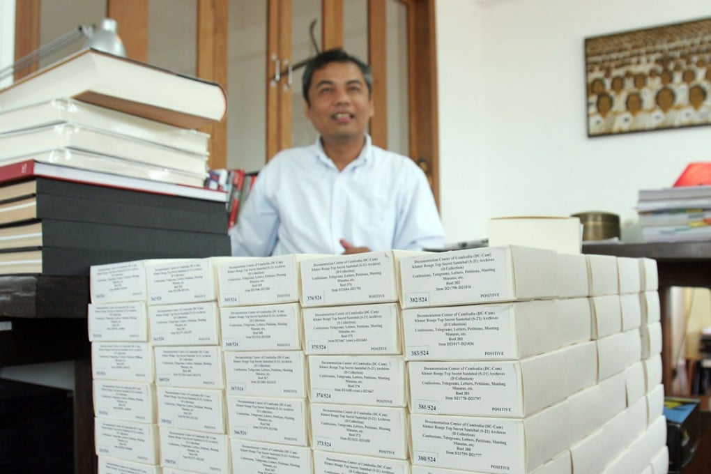Youk Chhang, director of the Documentation Center of Cambodia, stands behind boxes of microfilms containing documents about Khmer Rouge atrocities.