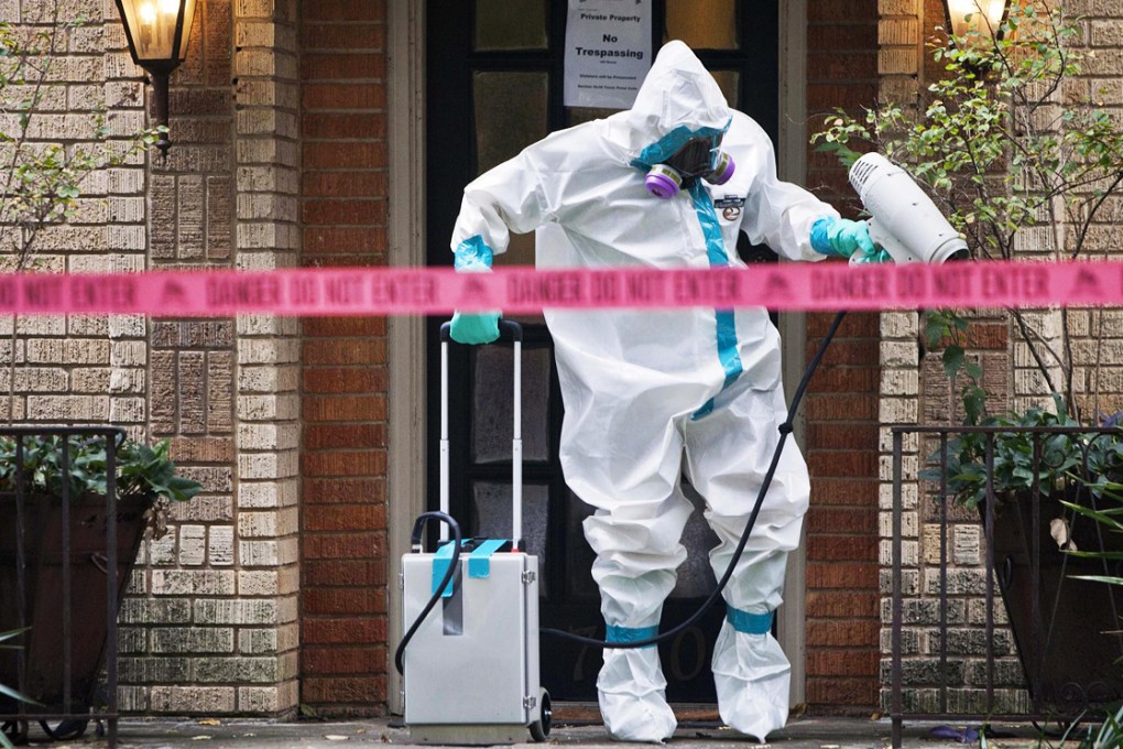 A specialist member of staff disinfects the entrance to the home of a Texas health worker who contracted Ebola. Photo: Reuters