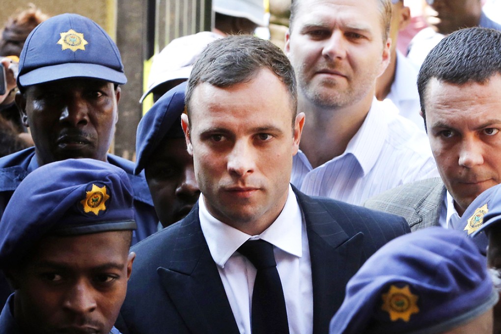 Oscar Pistorius is escorted by police as he arrives at Pretoria High Court on Monday. Photo: AP