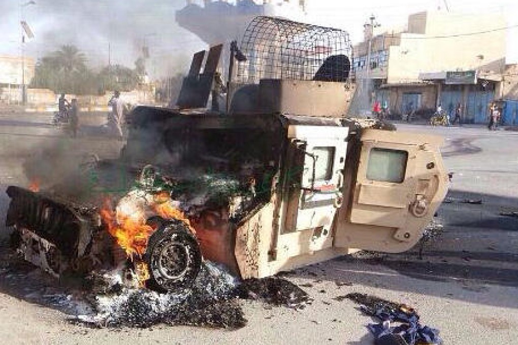 An Iraqi military vehicle burns in Anbar province. Photo: AP