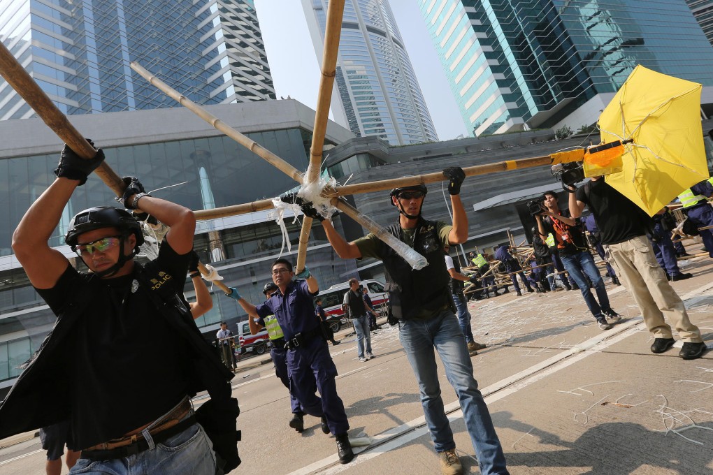 Police officers remove the barricades on Queensway in Admiralty. Photo: Sam Tsang