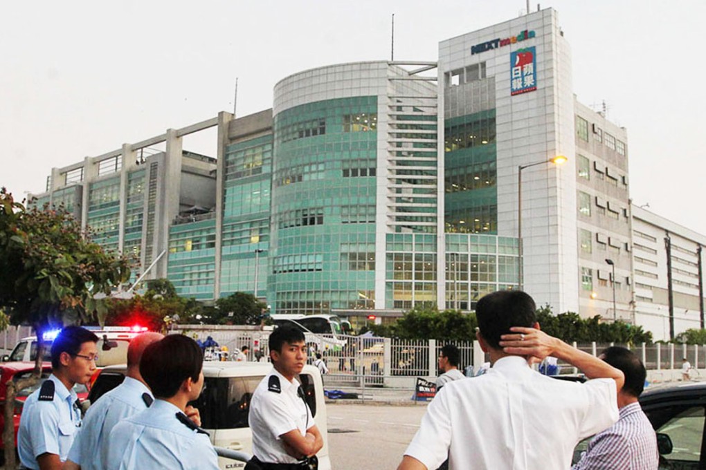 Police officers outside the Apple Daily offices in Tseung Kwan O.