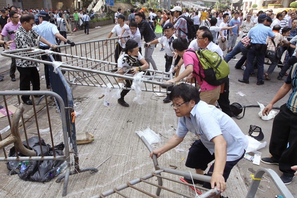 Supporters and opponents of the Occupy Central movement clash as they fight over barricades in Admiralty yesterday. Photo: Edward Wong