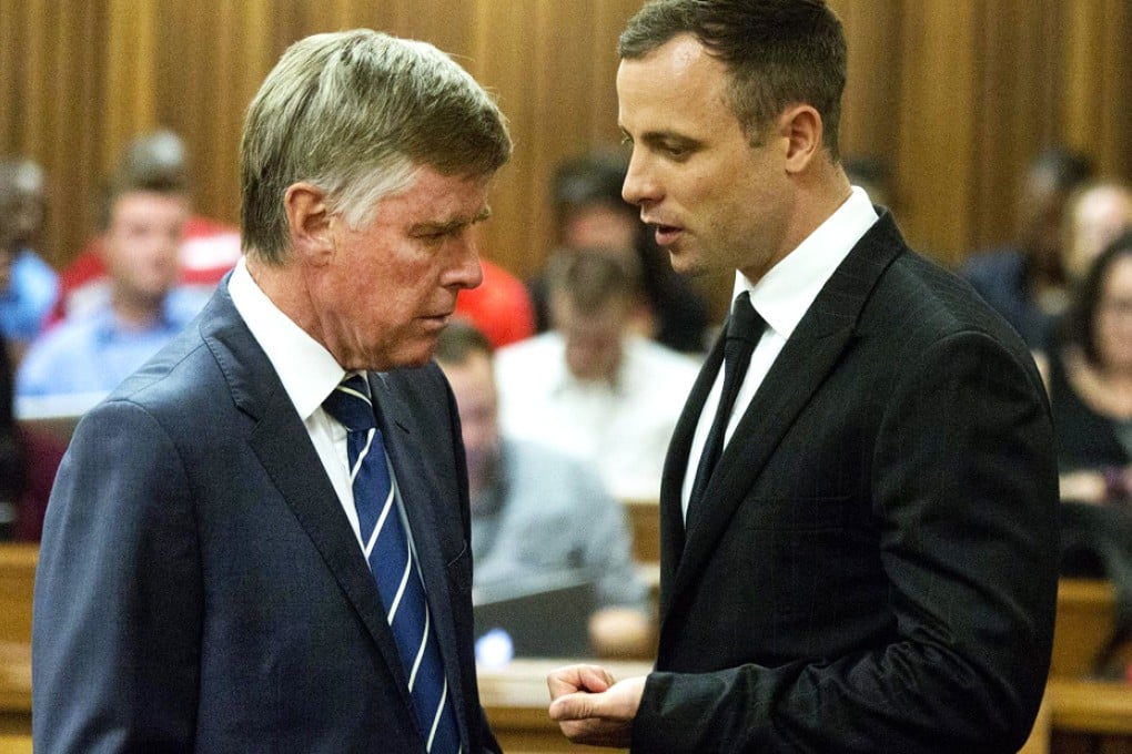 Oscar Pistorius (right) speaks with his lawyer. Photo: EPA