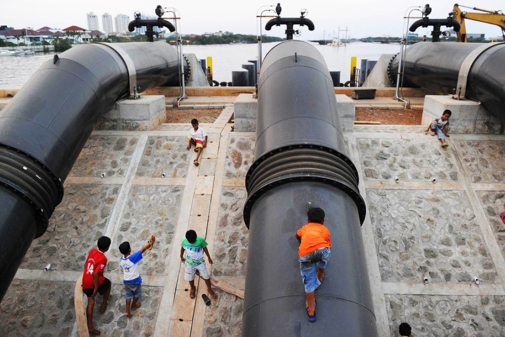 Part of the low sea defences that now protect Jakarta. The coastal, northern part of the capital is sinking as fast as 14cm a year. Photo: AFP