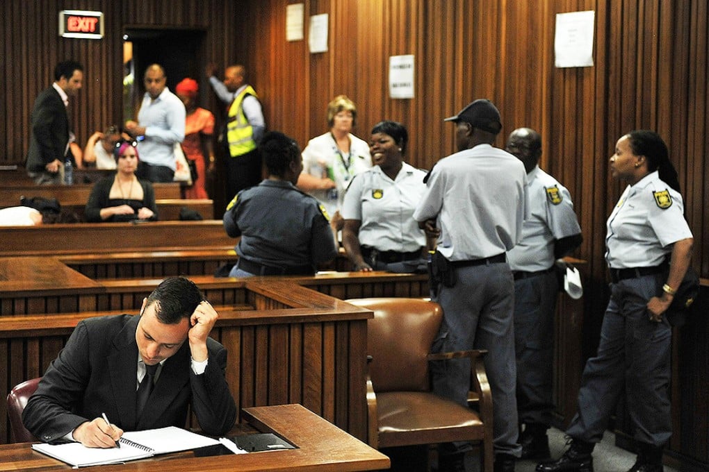 Oscar Pistorius takes notes on the third day of his sentencing during his ongoing murder trial in Pretoria. Photo: AFP