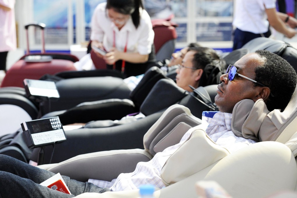 Buyers at the Canton Fair de-stress in massage chairs. Fears over Ebola and the economy may have hit attendance. Photo: Xinhua