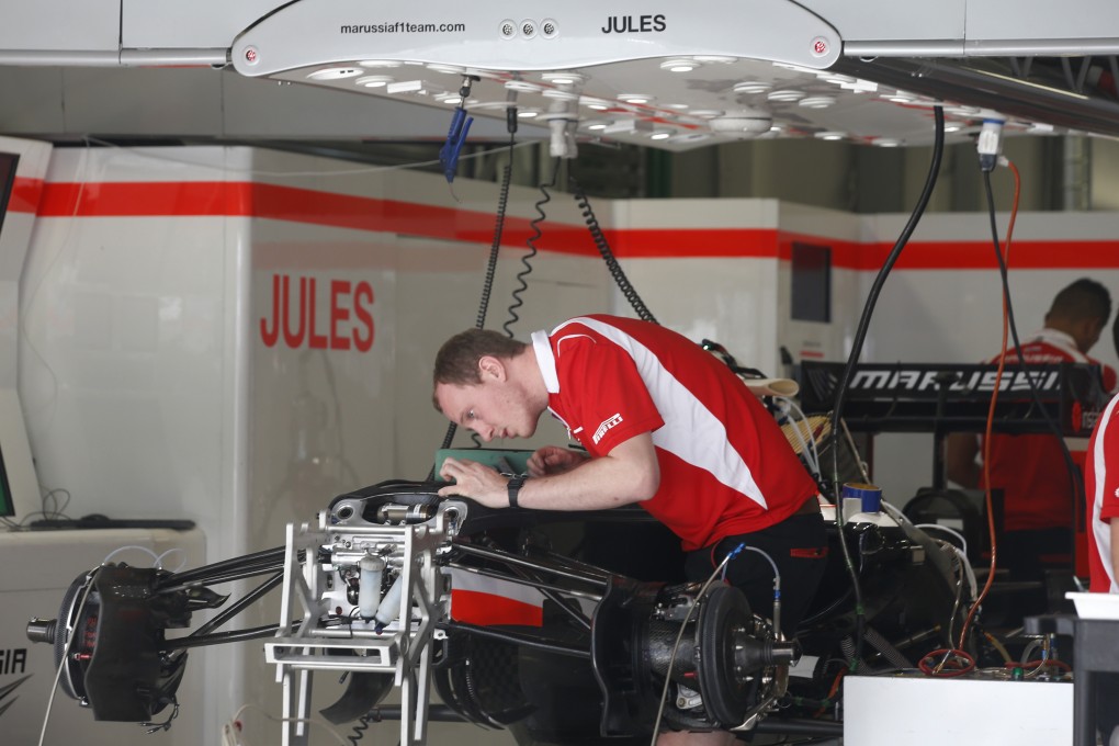 A Marussia mechanic works on a car in the Jules Bianchi garage at the Sochi Autodrom Formula One circuit. Photo: AP