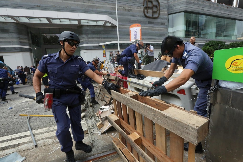 Officers remove barriers in Admiralty this week. Photo: Sam Tsang