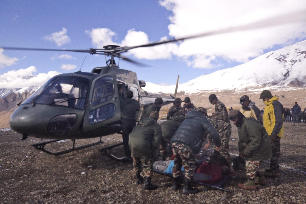Nepalese army rescuers carry the body of a trekker from the Thorong La mountain pass. Avalanches and severe weather claimed at least 30 lives, with more missing. Photo: EPA