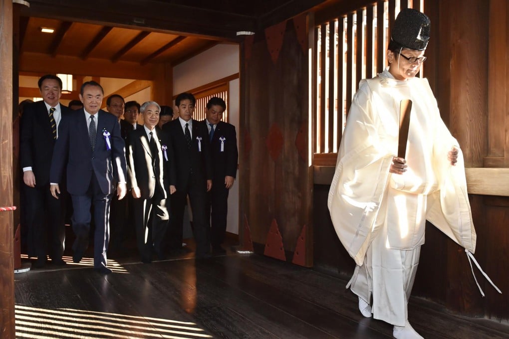 A group of Japanese parliamentarians follow a Shinto priest during a visit to the controversial Yasukuni war shrine yesterday. Photo: AFP
