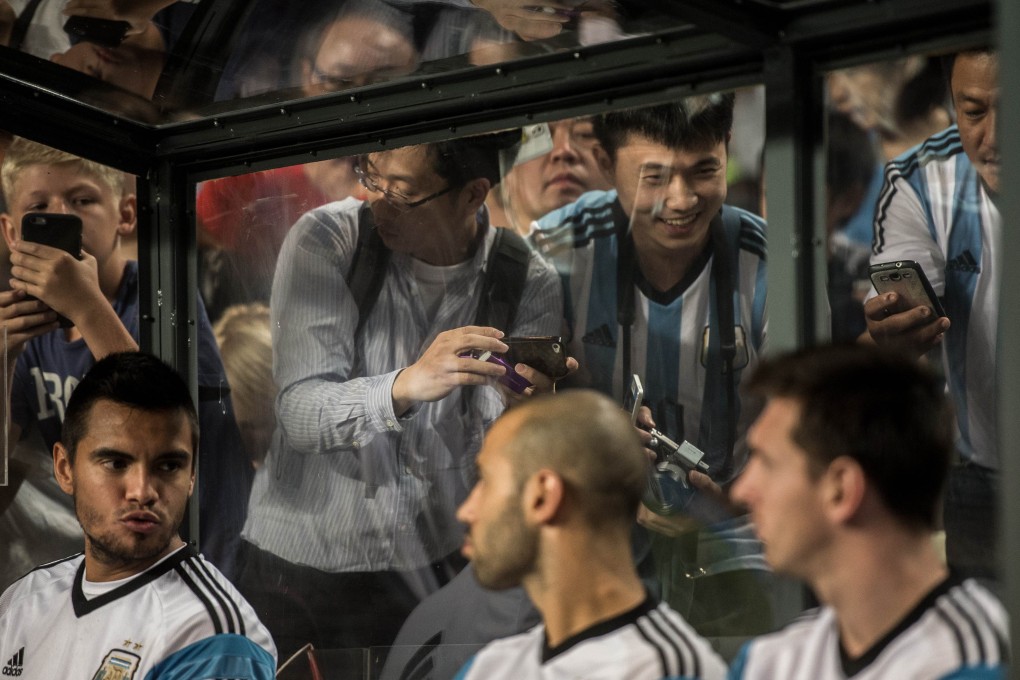 Fans try to capture a glimpse of their hero Lionel Messi. He ended up costing the HKFA HK$1 million per minute during last week's Hong Kong v Argentina game Photo: AFP