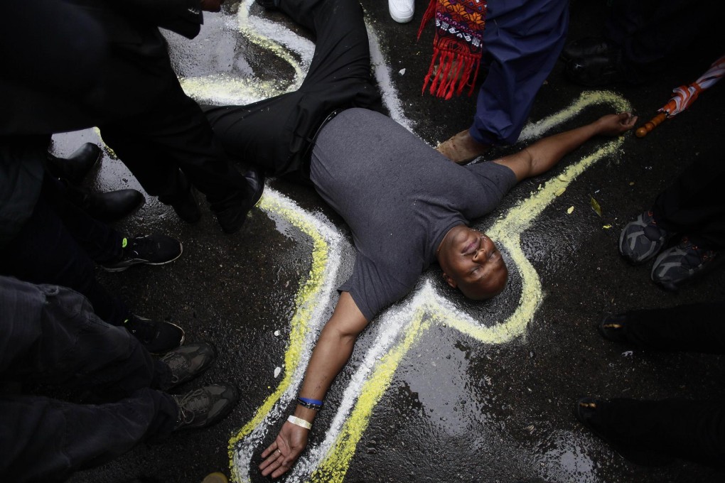 A man has his body outlined with chalk to replicate a crime scene during a protest at the shooting of Michael Brown. Photo: AFP