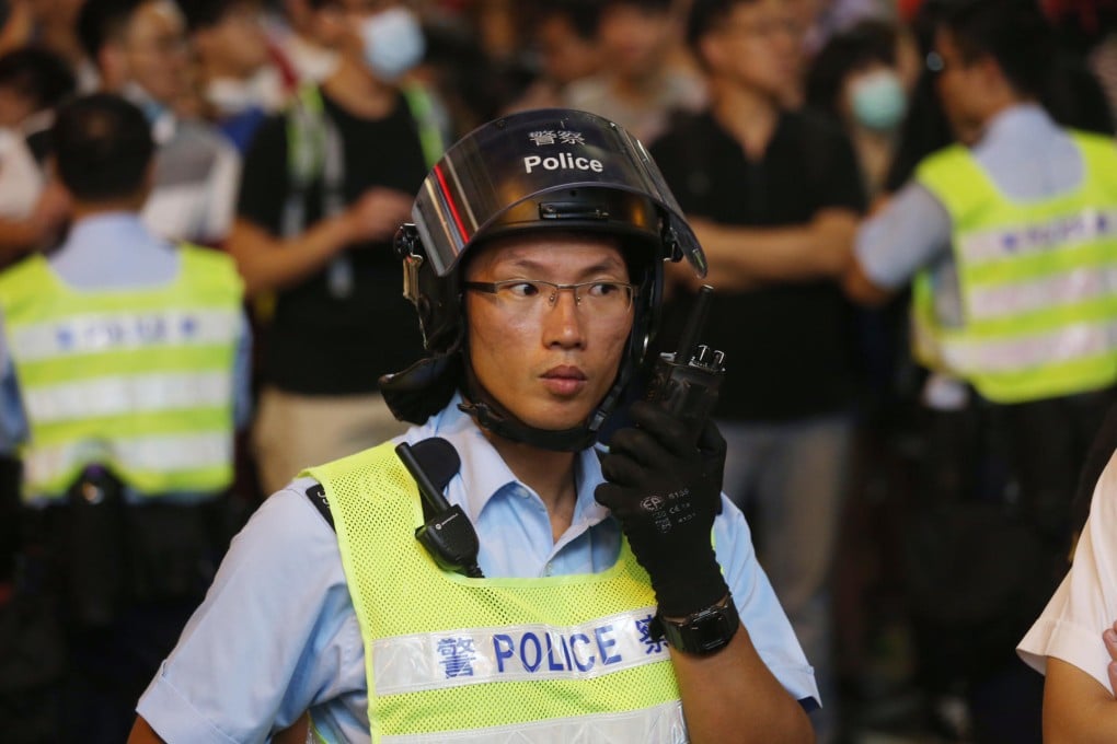 A vest conceals the ID number of a police officer. Photo: K. Y. Cheng