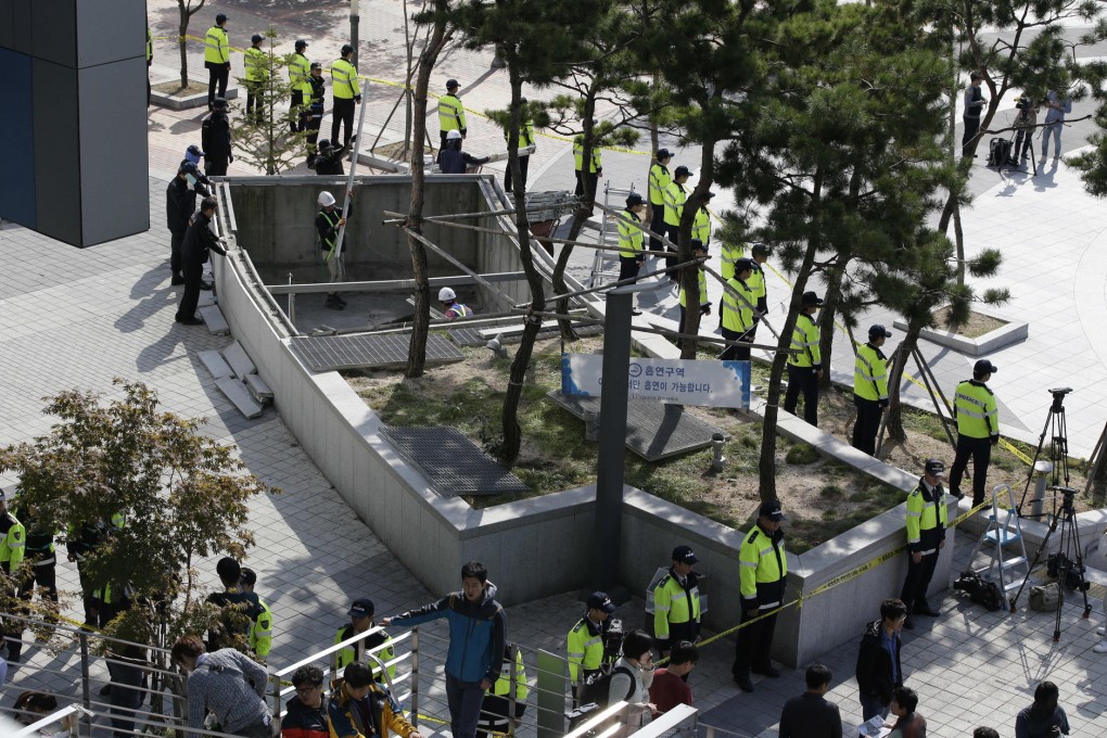 Officials work on the site of the collapsed grate. Photo: AP