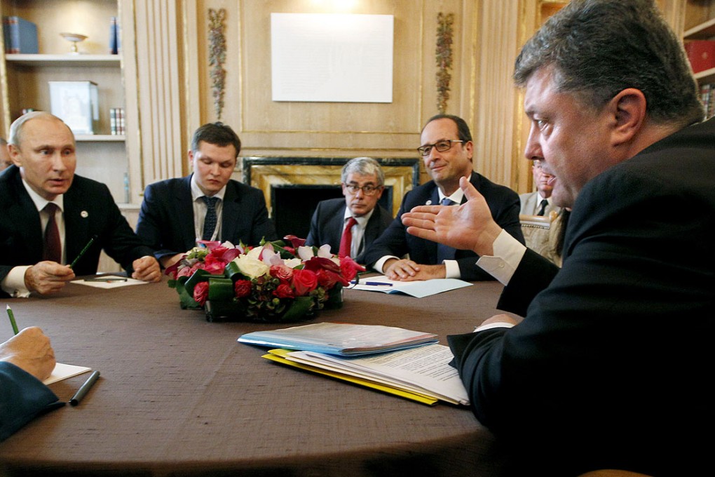 Ukrainian President Petro Poroshenko, (right), talks with Russian President Vladimir Putin, (left), as French President Francois Hollande listens during a meeting in Milan, Italy on Friday. Photo: AP