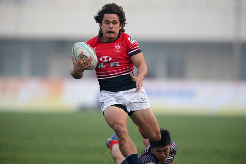 Hong Kong's Rowan Varty slips the Singapore defence en route to a 33-0 pool victory at the China Sevens on Saturday. Photos: HKRFU