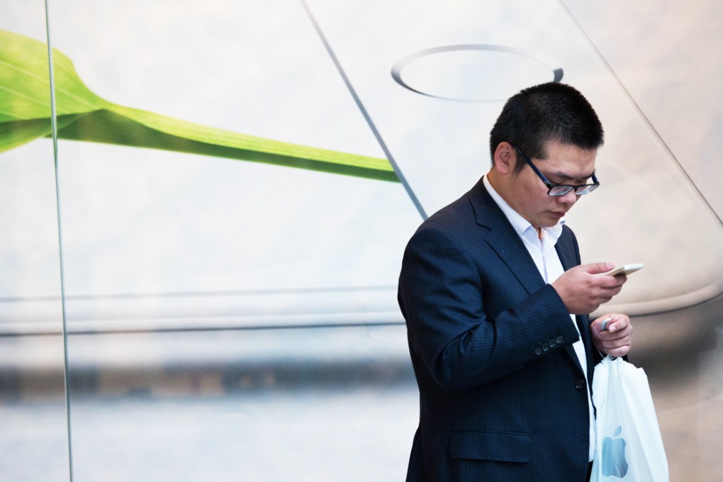 A man holds his new iPhone 6 in front of an Apple store in Shanghai on Friday. Photo: AFP