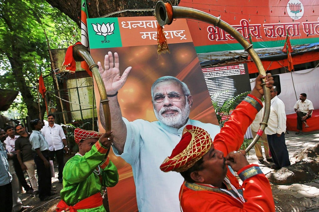 BJP supporters celebrate in front of a poster of PM Narendra Modi outside the party's offices in Mumbai, capital of Maharashtra, on Sunday. Photo: Reuters