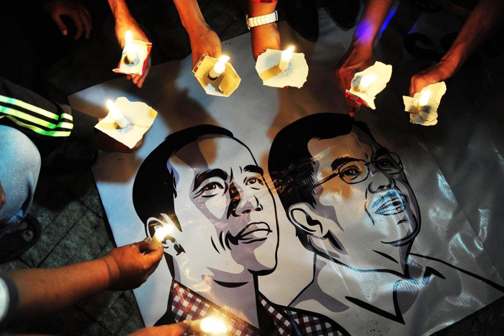 A candlelit prayer vigil in Jakarta honours Indonesian president-elect Joko Widodo (left) ahead of his inauguration. Photo: Xinhua