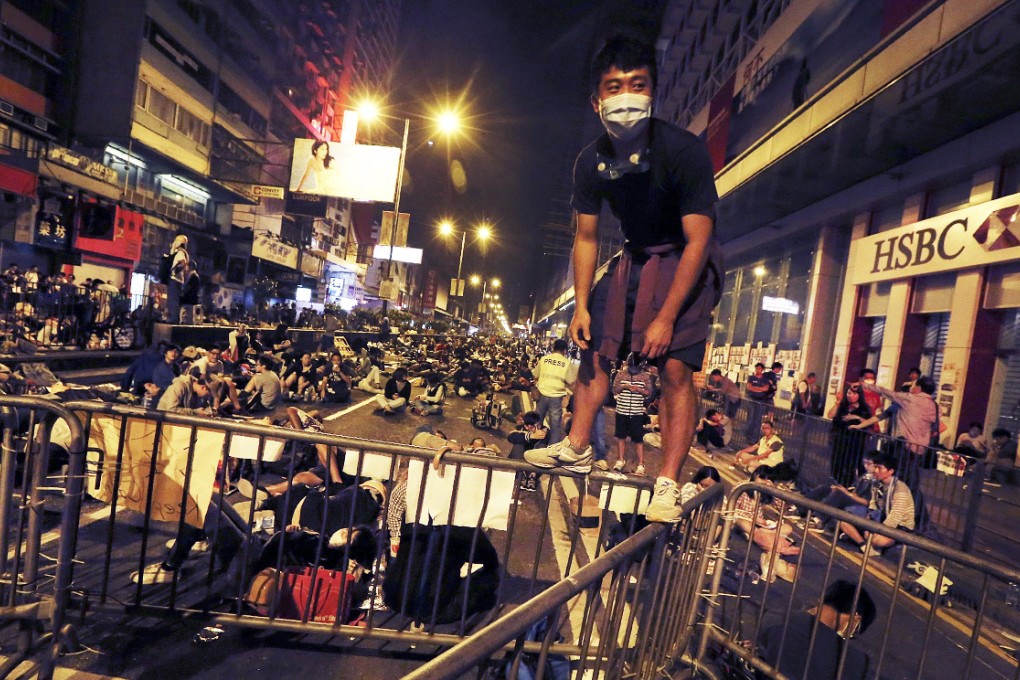 A pro-democracy protester stands on a barricade in Mong Kok, the high court has ordered demonstrators there to clear the streets. Photo: EPA