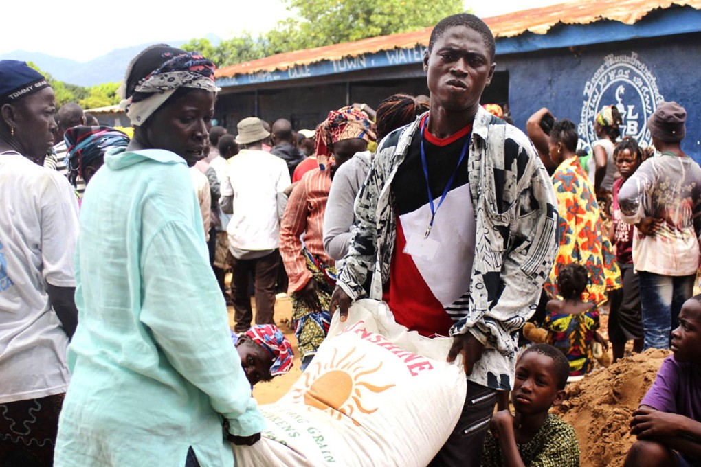 People carry a bag of rice at a World Food Programme distribution point. Photo: Reuters