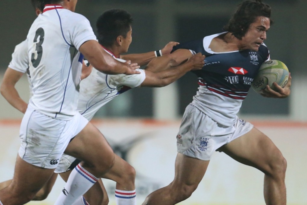 Hong Kong's Rowan Varty tries to shrug off a South Korea tackler in the China Sevens final on Sunday. Photo: HKRFU