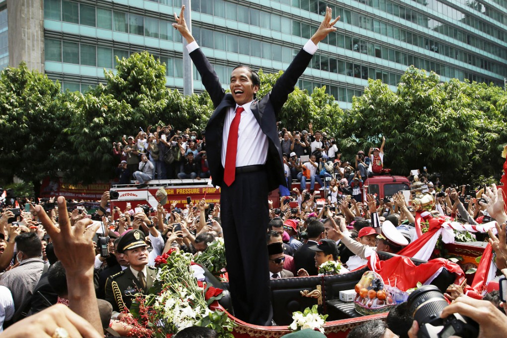 Indonesian President Joko Widodo salutes the crowd following his inauguration in Jakarta yesterday. Nine heads of state attended the ceremony, while other nations including China were represented by ministers. Widodo, 53, is the country's first president who has no ties with late strongman Suharto or other political elites. Photo: AP