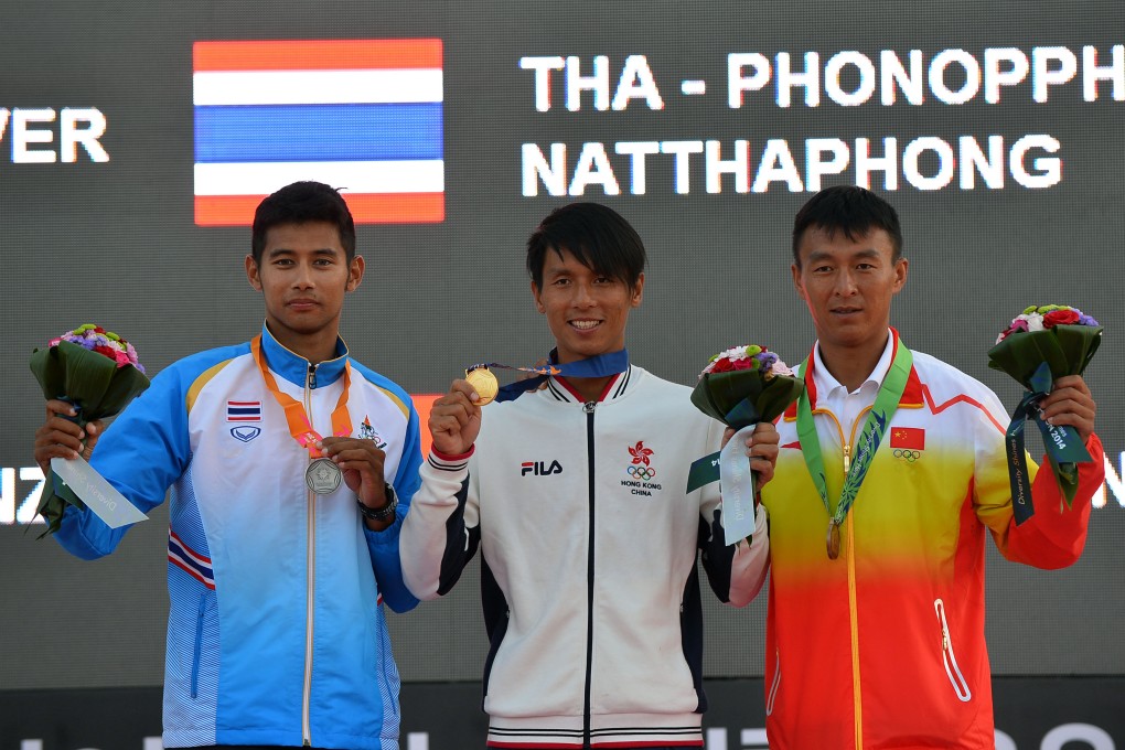 Gold medallist Cheng Kwok Fai (centre) of Hong Kong,  with silver medallist Phonoppharat Natthaphong (left) of Thailand and bronze winner Shi Chuankun of China at the award ceremony of the mistral men's windsurfing event. Photo: Xinhua
