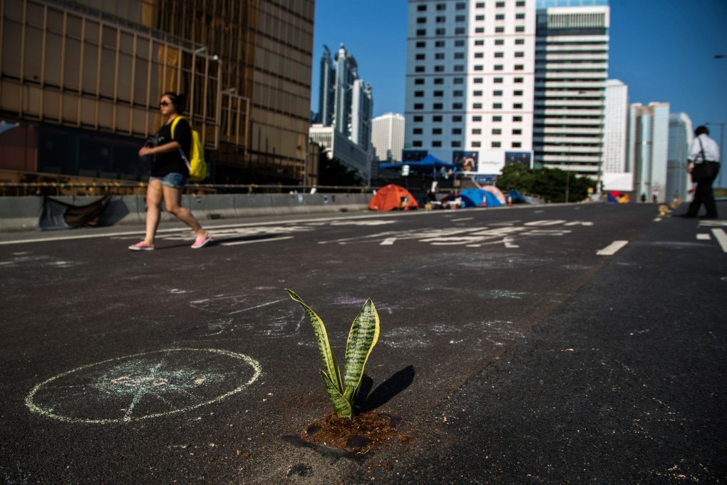 Commuters walk on Connaught Road Central as the demonstrations enter their third week. Photo: Bloomberg