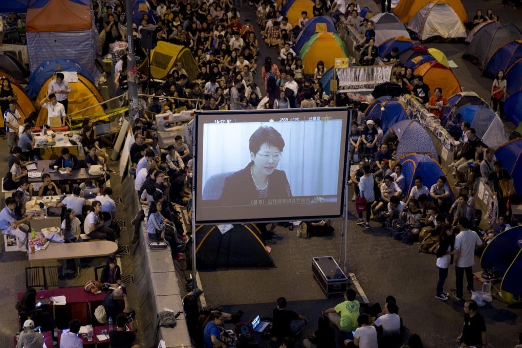 Protesters watch the talks live on TV. Photo: Bloomberg