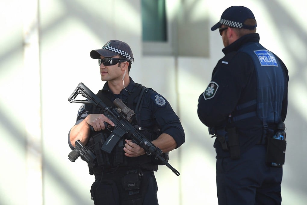 Heavily-armed Australian Federal Police officers at the entrance to Parliament House in Canberra on Thursday. Photo: EPA