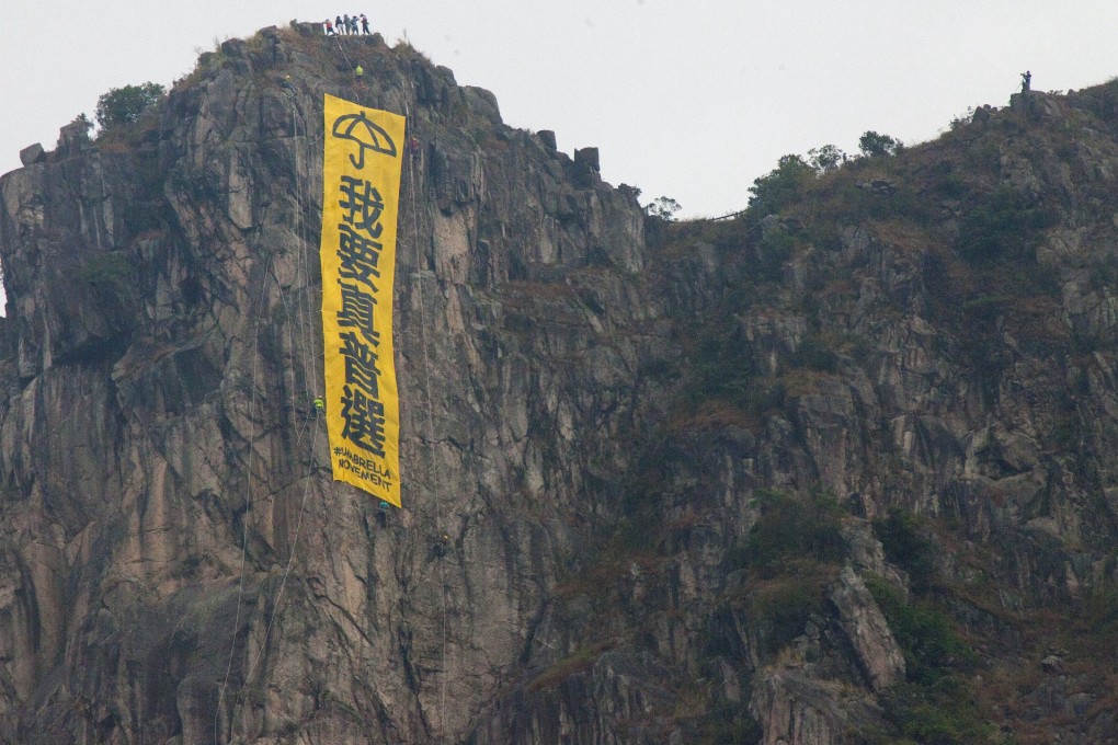 A banner calling for universal suffrage hangs on the iconic Lion Rock. Photo: EPA