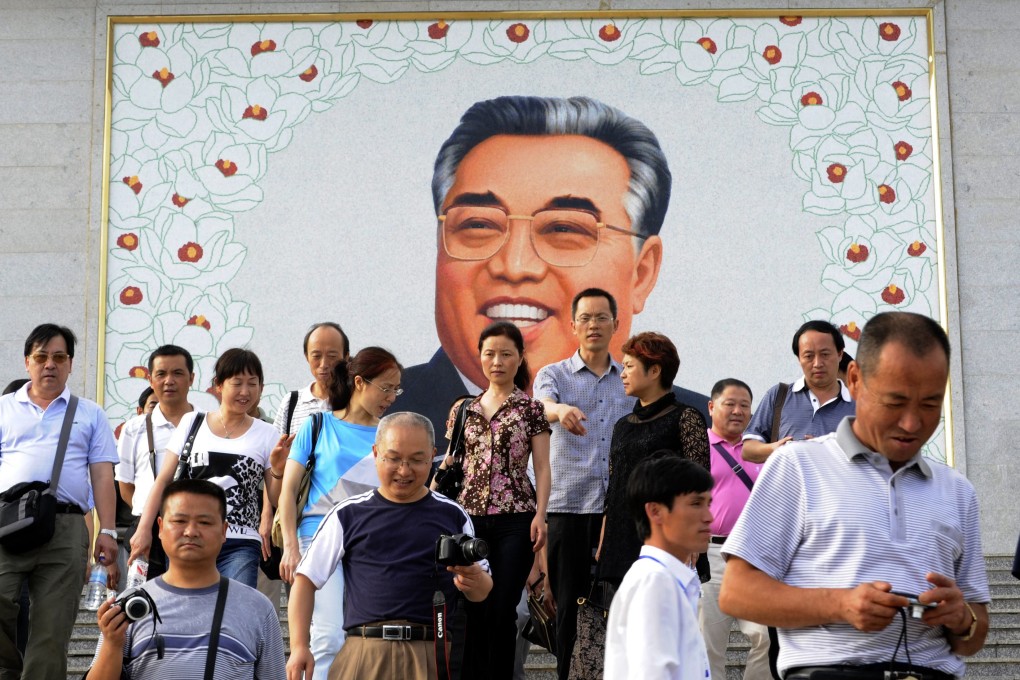 Tourists leaving after paying homage to a giant portrait of Kim Il-Sung. Photo: AFP