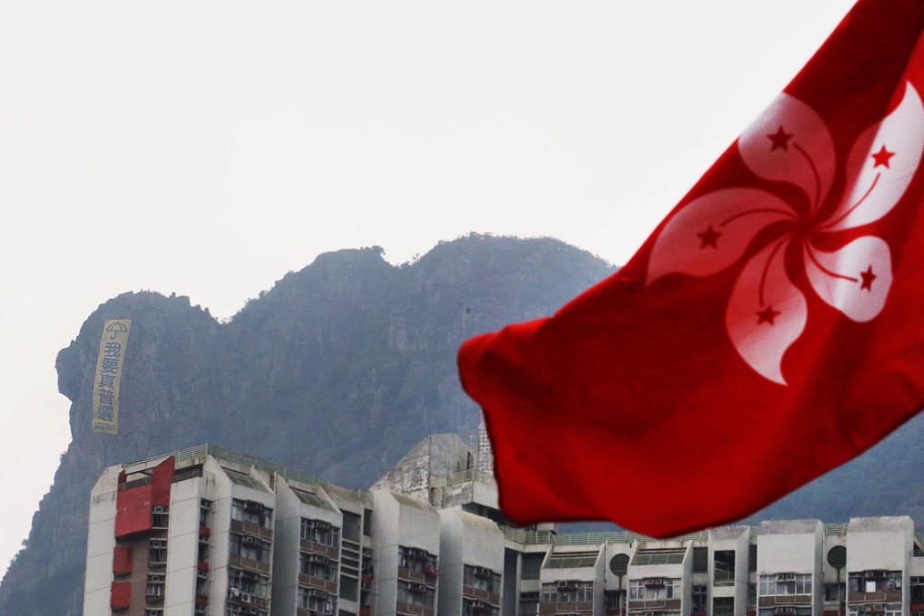 Protesters hung a large banner stating 'we want universal suffrage' at Lion Rock overlooking Kowloon on Thursday. Photo: Felix Wong
