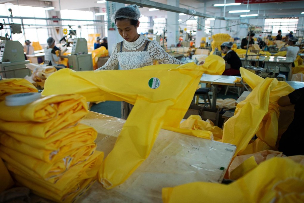 Workers from Lakeland Industries in Weifang city, Hebei, work on protective suits used to treat people infected with Ebola. Photo: AFP