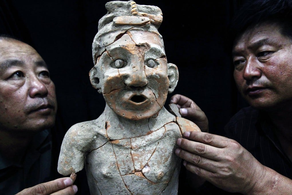 Archaeologists repair a terracotta portrait discovered in China's Inner Mongolia Autonomous Region. It is unknown how many artifacts have been stolen by grave robbers. Photo: Xinhua