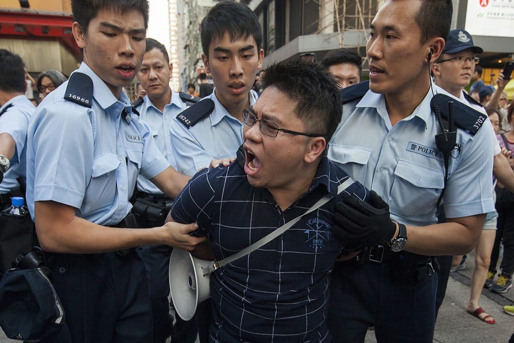 Police officers in Mong Kok lead away an anti-Occupy protester. Photo: EPA
