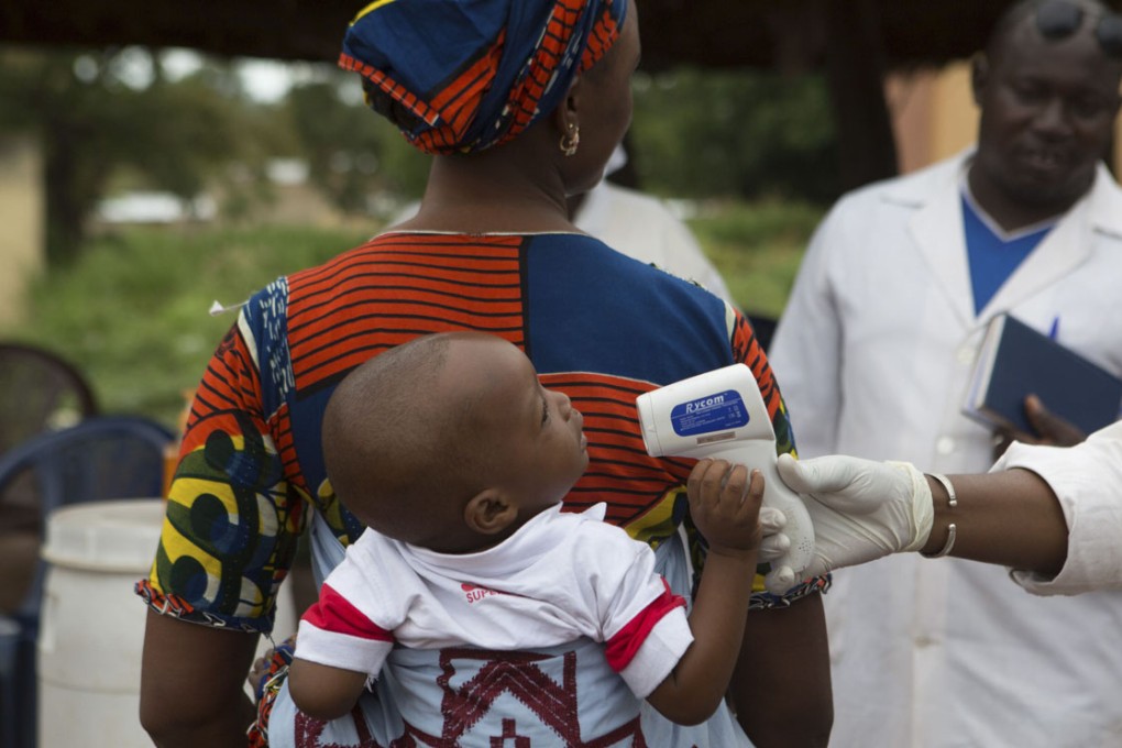A health worker checks the temperature of a baby entering Mali from Guinea earlier this month. Photo: Reuters